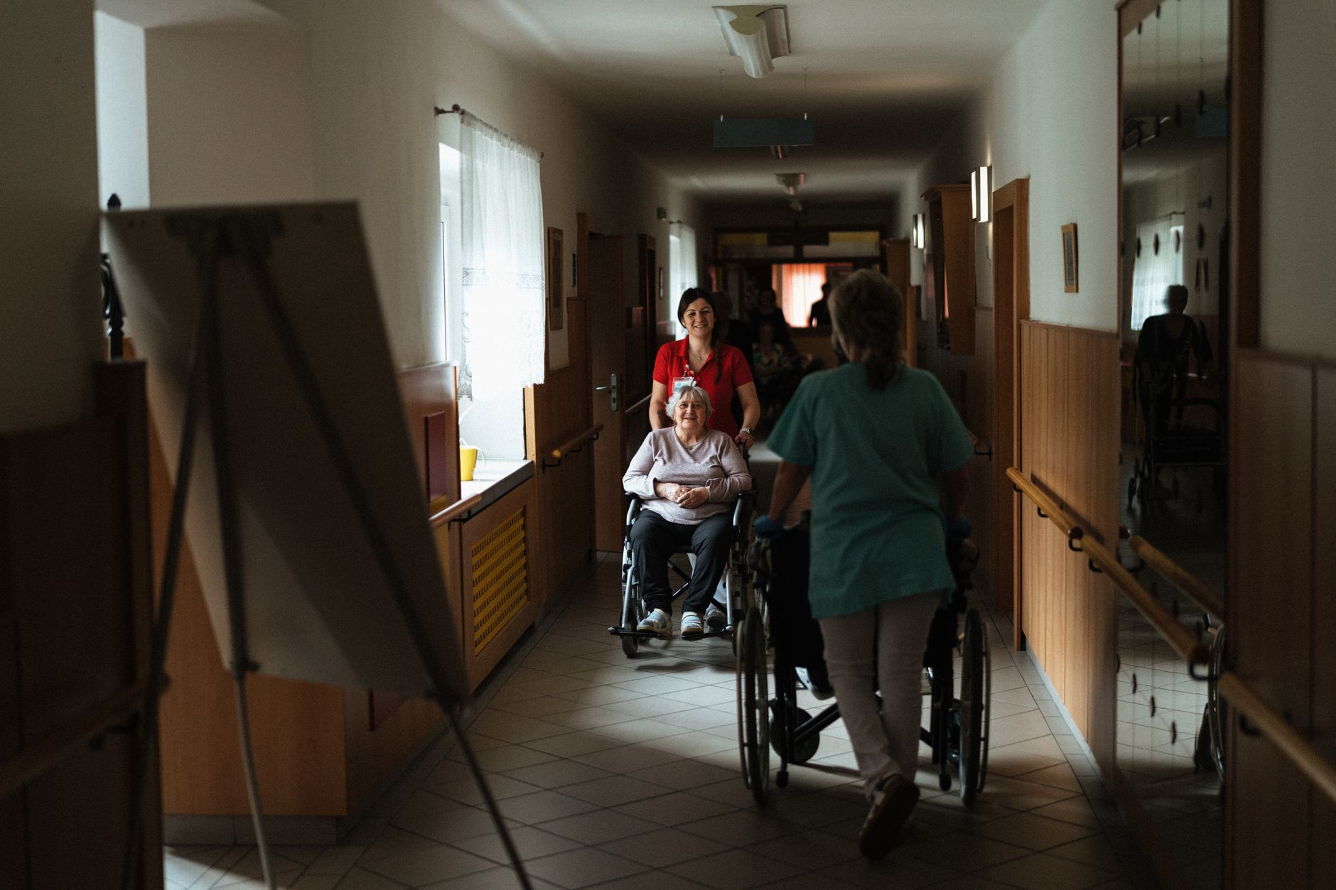 Caregiver assisting elderly woman in a wheelchair, representing long-term care cost planning