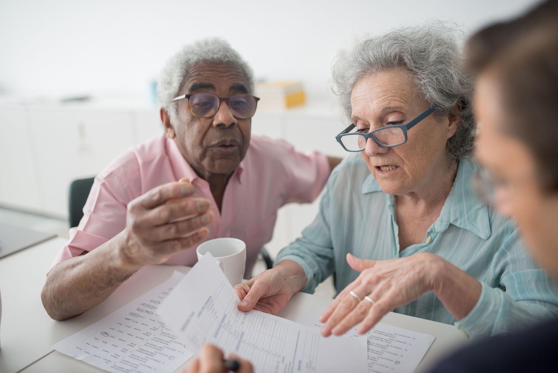 Elderly couple reviewing Medicare and Medigap coverage paperwork with an advisor