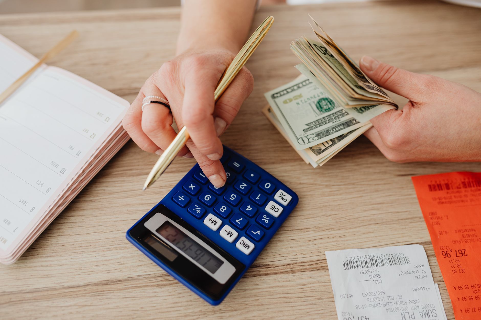 Hands handling cash and calculator for retirement budget planning
