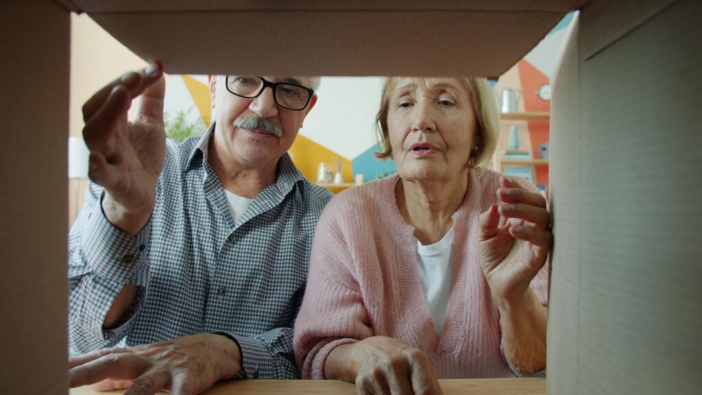 Senior couple opening moving boxes in a new home after relocating to a retirement-friendly state