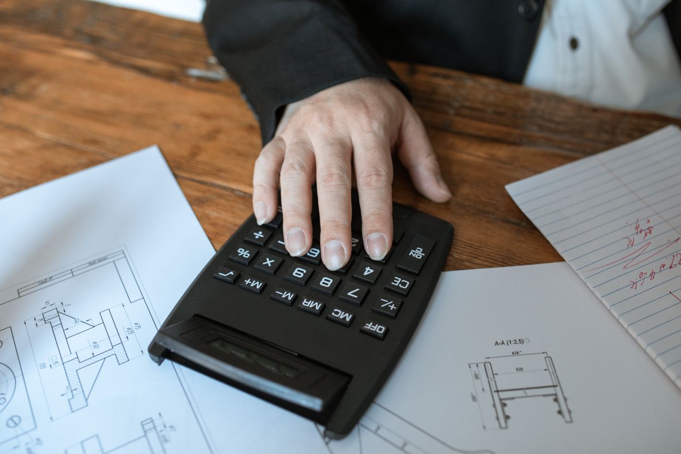 Close-up of a person using a calculator to figure out their withdrawal order calculator result